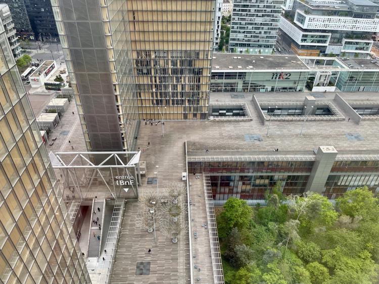 A view from the top of one of the towers down into the courtyard. You can see the base of one tower, and the walkways that lead to the entrance. You can also see some of the trees in the wooded area, which is below ground level.